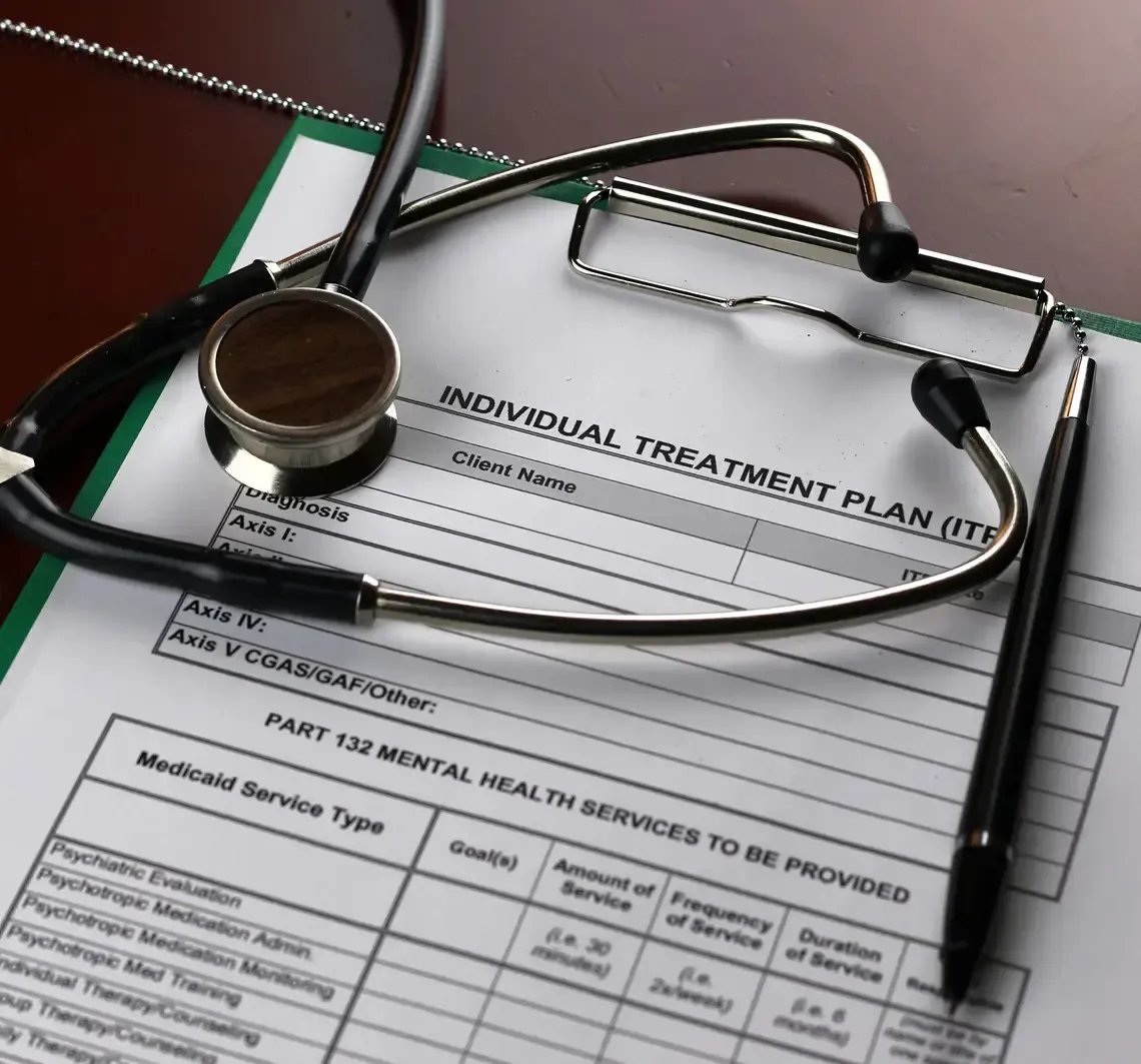 Stethoscope on a mental health treatment plan form with a clipboard and pen