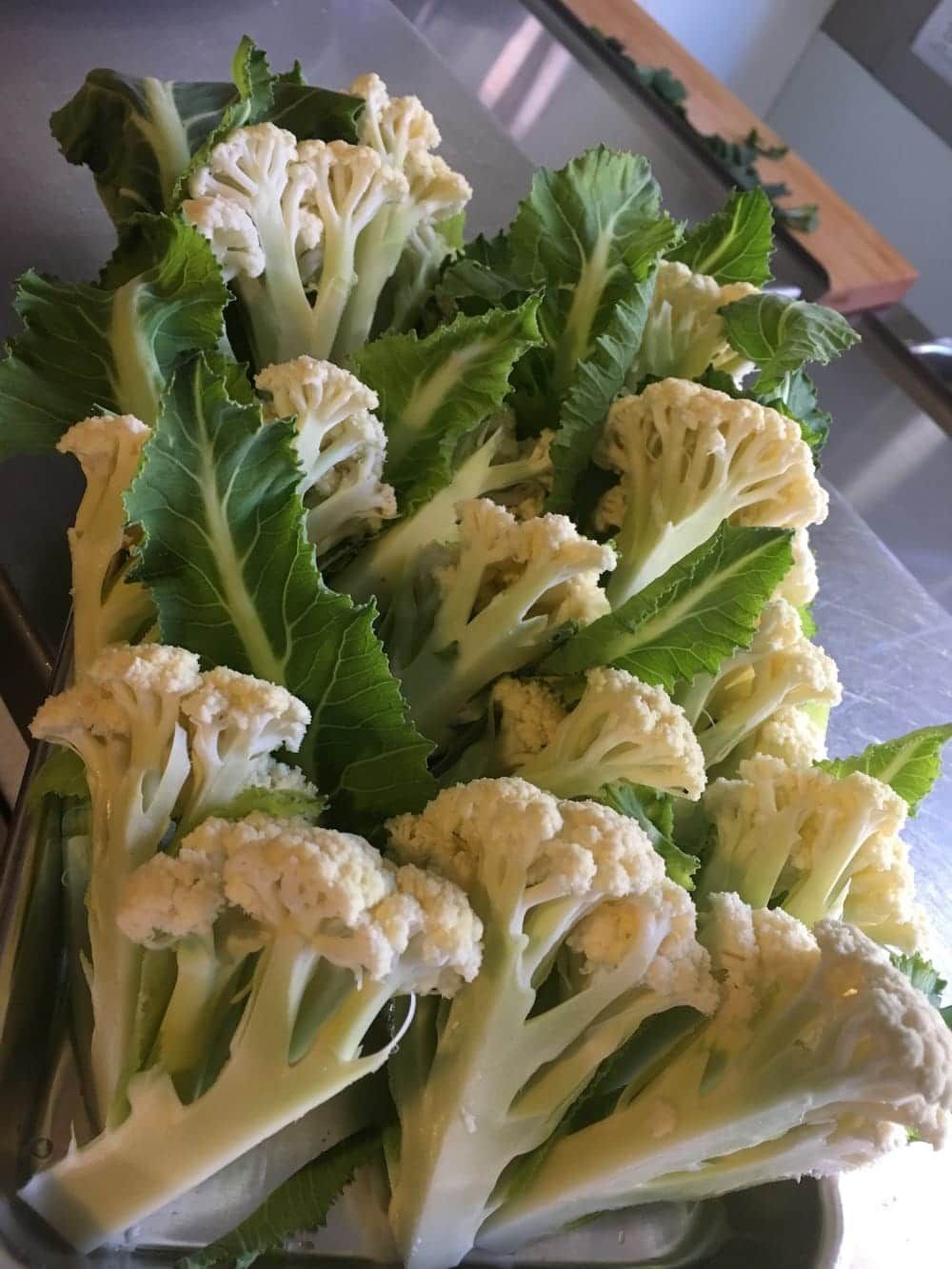 A bunch of cauliflower with green leaves on a table
