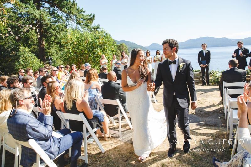 A bride and groom are walking down the aisle at their wedding.