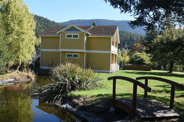 A house with a bridge over a pond in front of it
