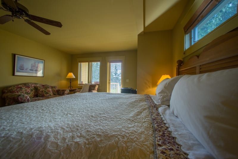 A bedroom with a king size bed and a ceiling fan.