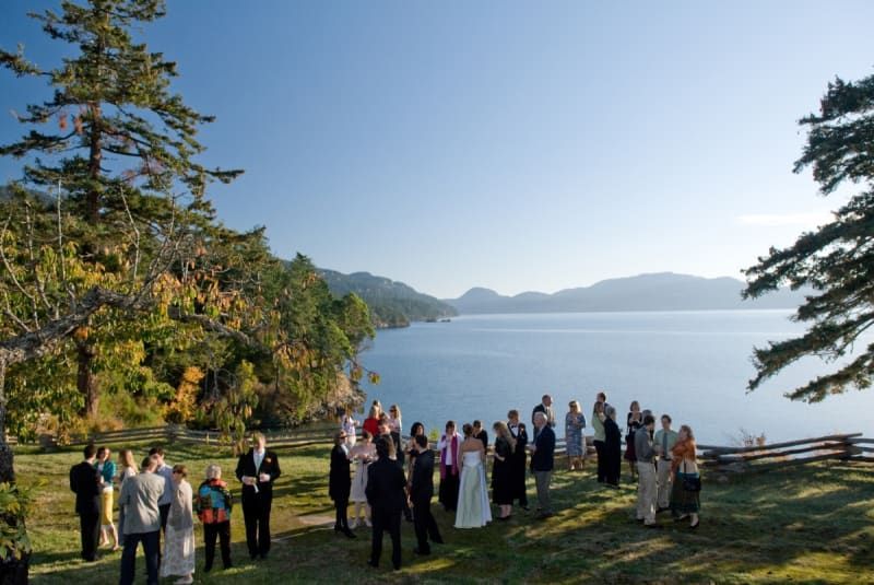 A group of people standing in front of a lake