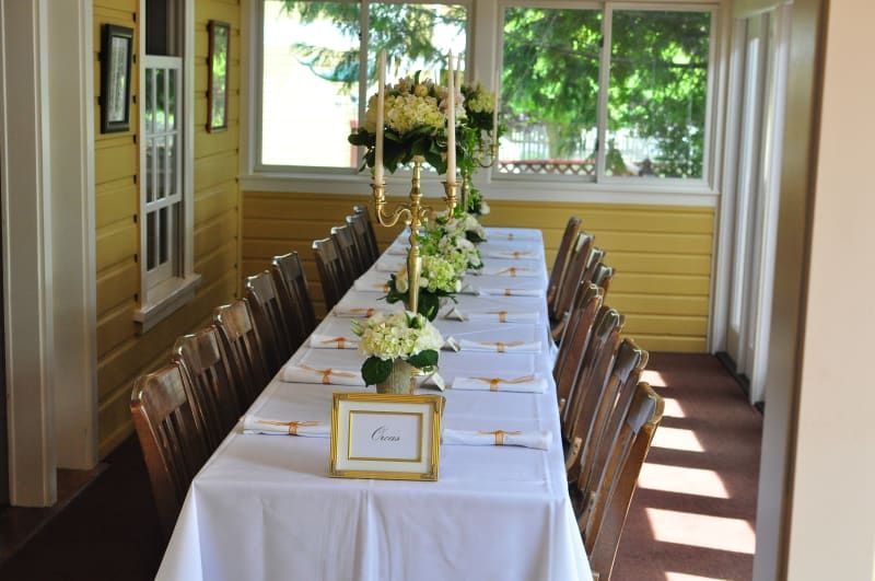 A long table with candles and flowers on it in a room.