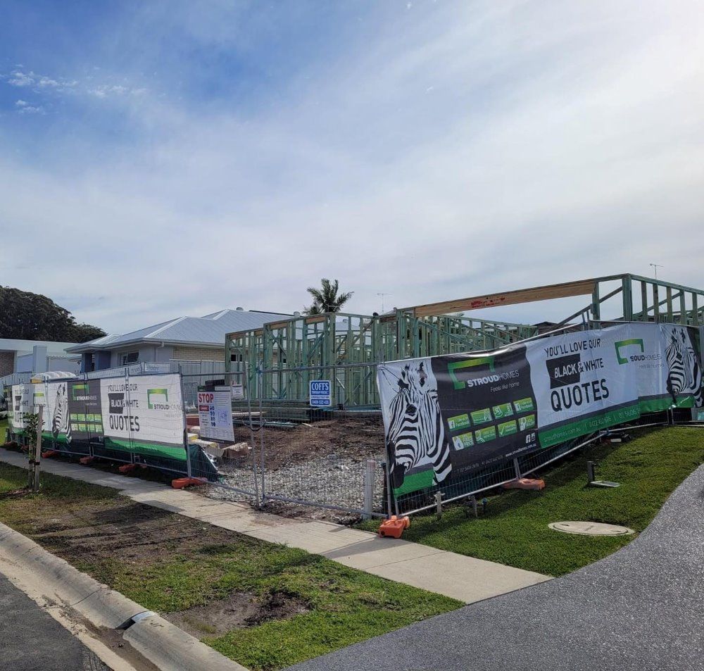 A Construction Site With A Fence And A Sign — Coffs Temporary Fencing Pty Ltd In Woolgoolga, NSW