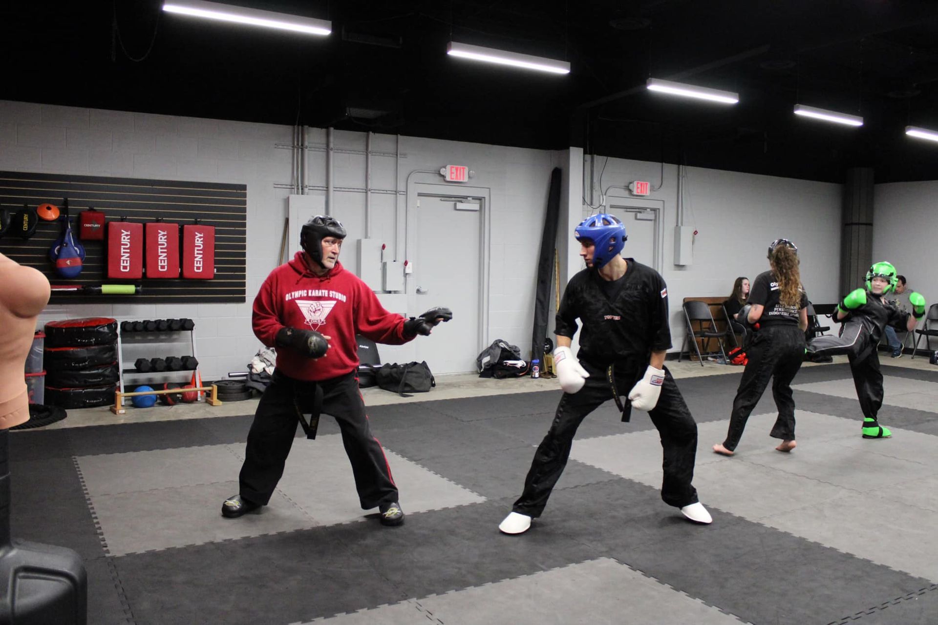 A group of people are practicing martial arts in a gym.
