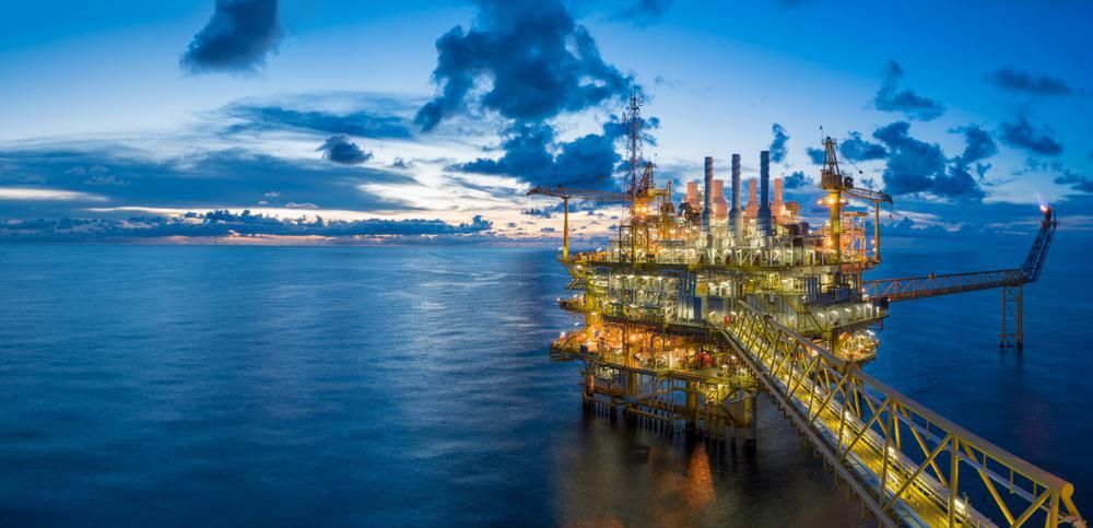 An oil rig in the middle of the ocean at night.