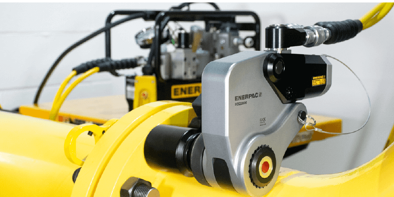 A machine is sitting on top of a yellow pipe.