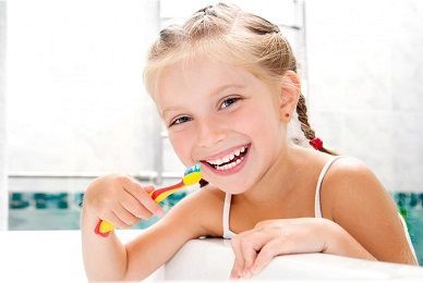 Bambino sorridente che si lava i denti in un bagno luminoso