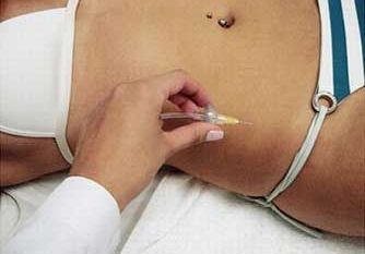 Un operatore sanitario somministra un'iniezione nell'addome di un paziente.