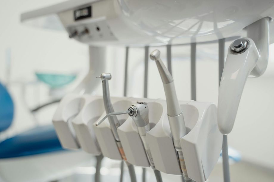 Strumenti per trapano dentale in un supporto sotto la poltrona del dentista, in una luminosa stanza della clinica.