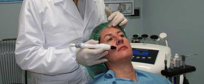 Un dentista esamina la bocca di un paziente con una mano guantata e uno strumento in una clinica odontoiatrica.