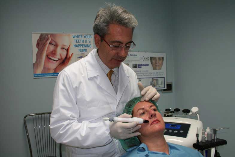 In una clinica, un dentista esamina la bocca di un paziente con le mani guantate