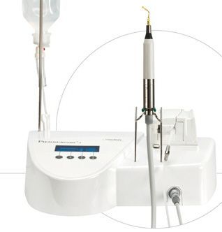 Manipolo ablatore dentale bianco su unità base con display e comandi, mostrato con un inserto circolare ingrandito.