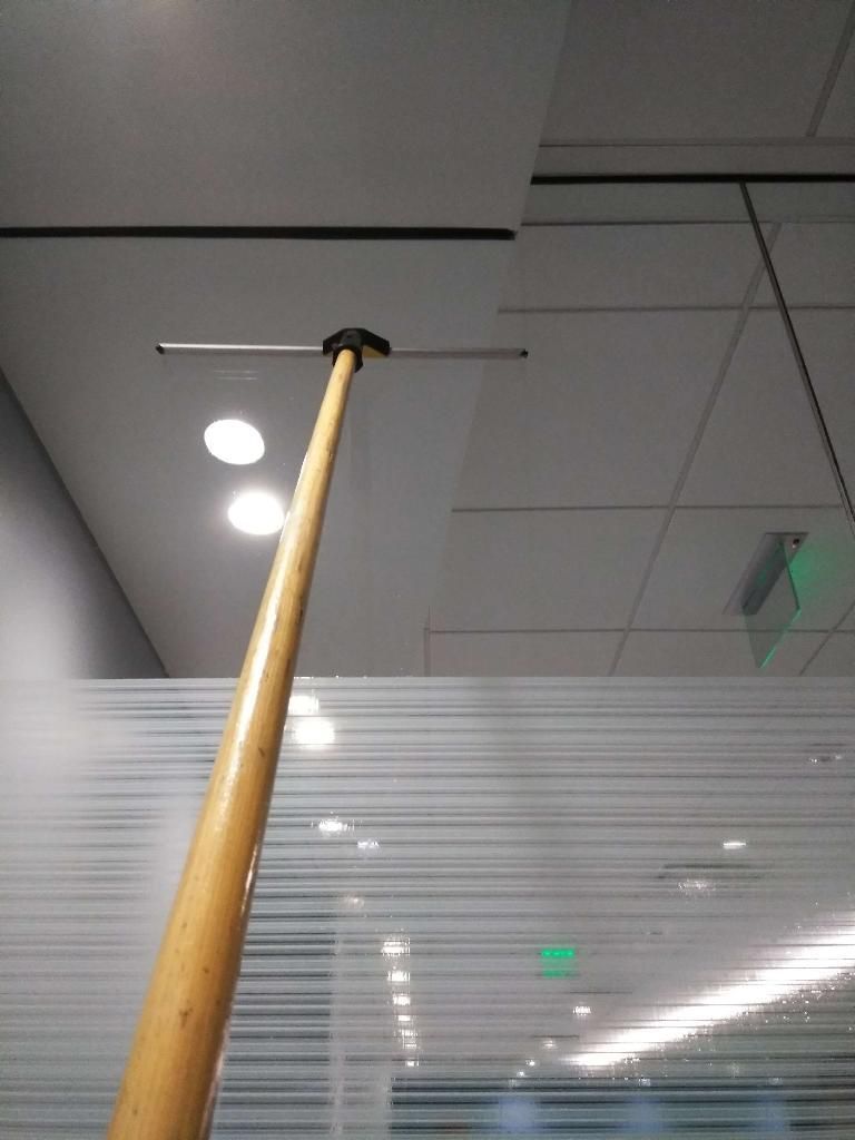A wooden pole is hanging from the ceiling in a room