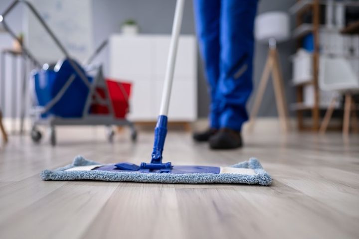 A person is cleaning the floor with a mop.