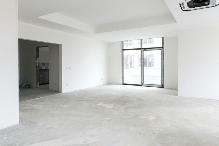 An empty room with white walls and a concrete floor.