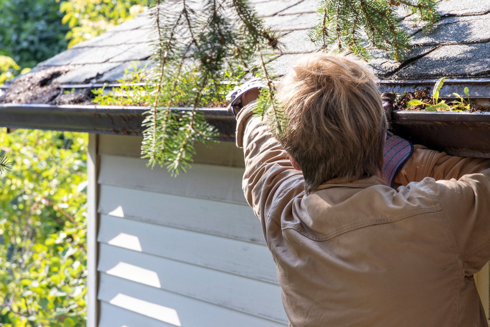 Man cleaning roof gutter