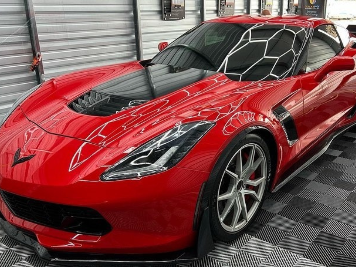 Red Corvette sports car on a black and white checkered floor.