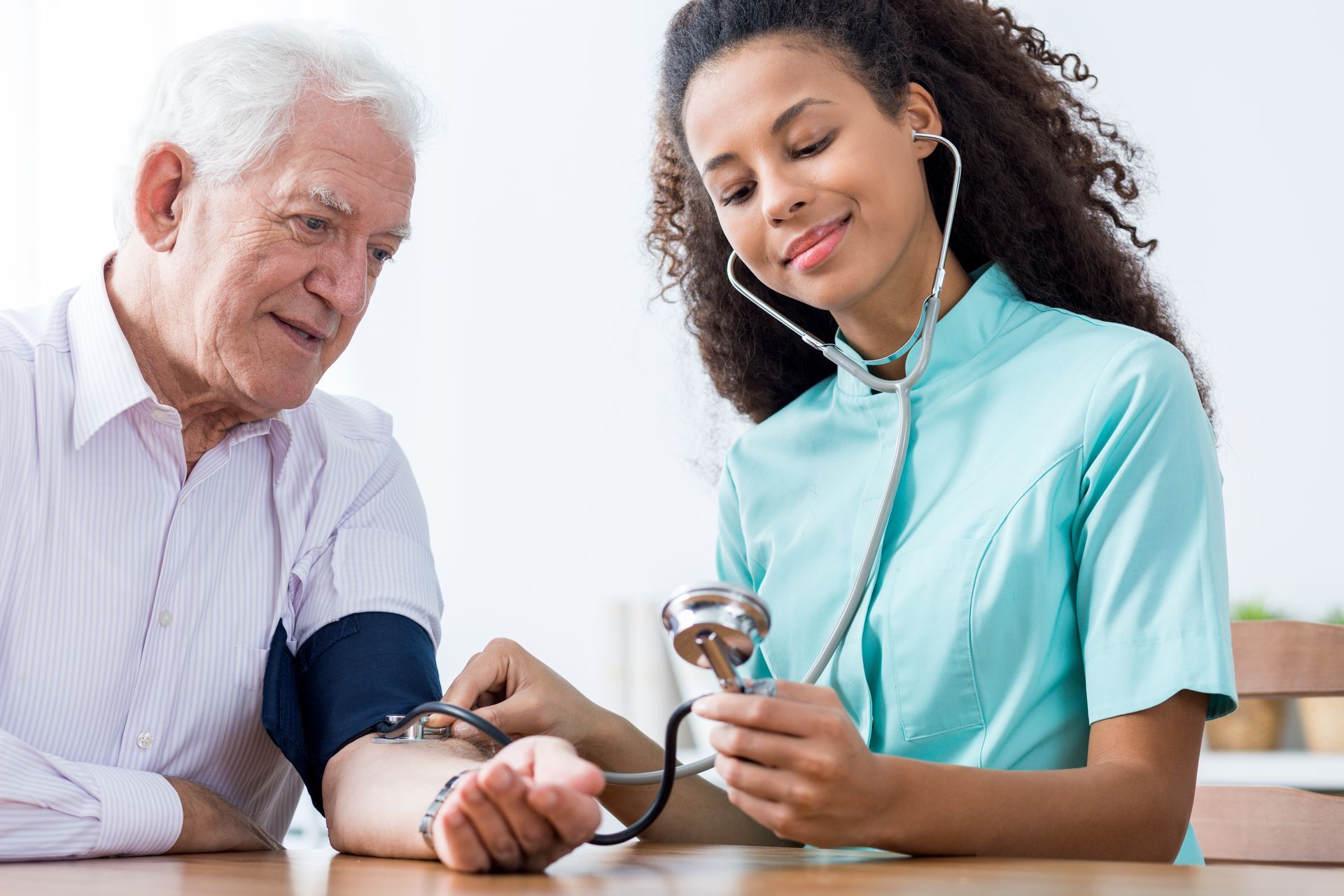 A healthcare worker taking a patient's blood pressure.
