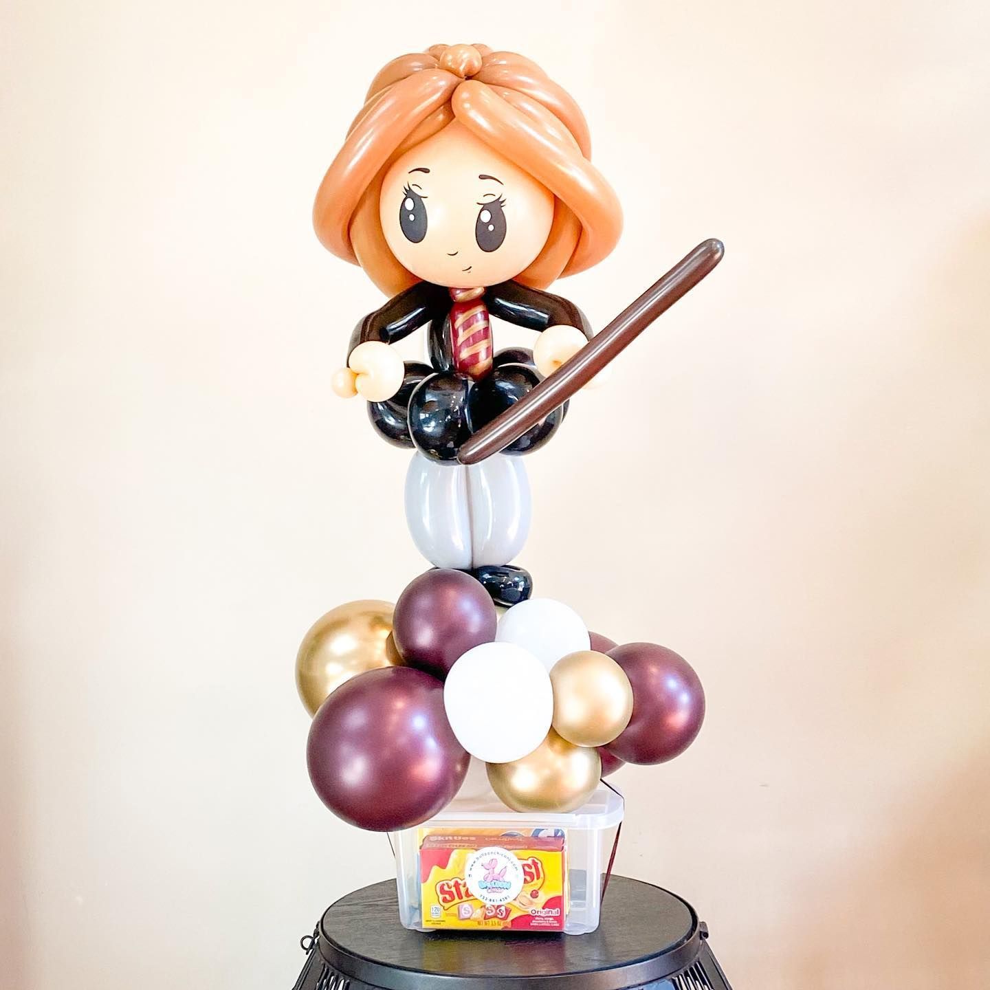 a girl made out of balloons is holding a wand