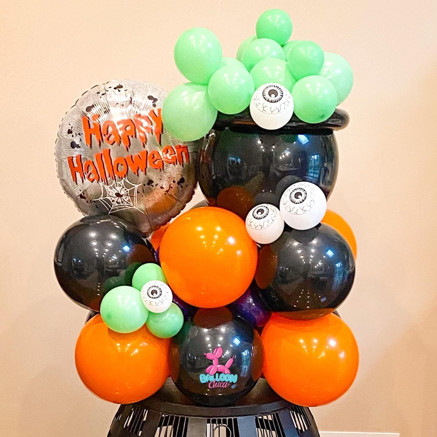 a bunch of halloween balloons are stacked on top of each other on a table