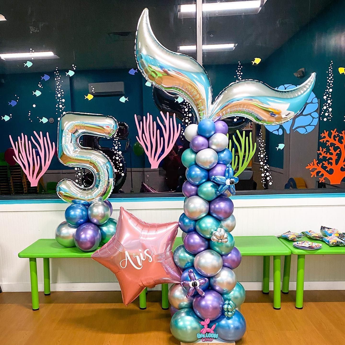 a mermaid tail balloon is sitting on top of a balloon tower .