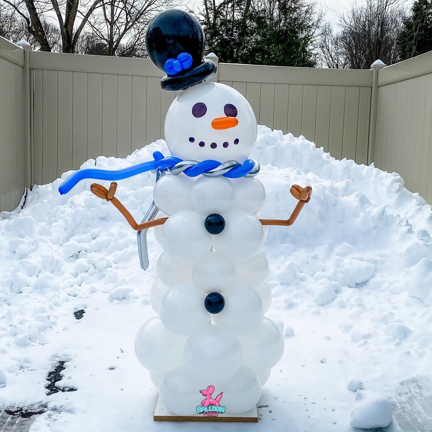 a snowman made out of balloons is standing in the snow