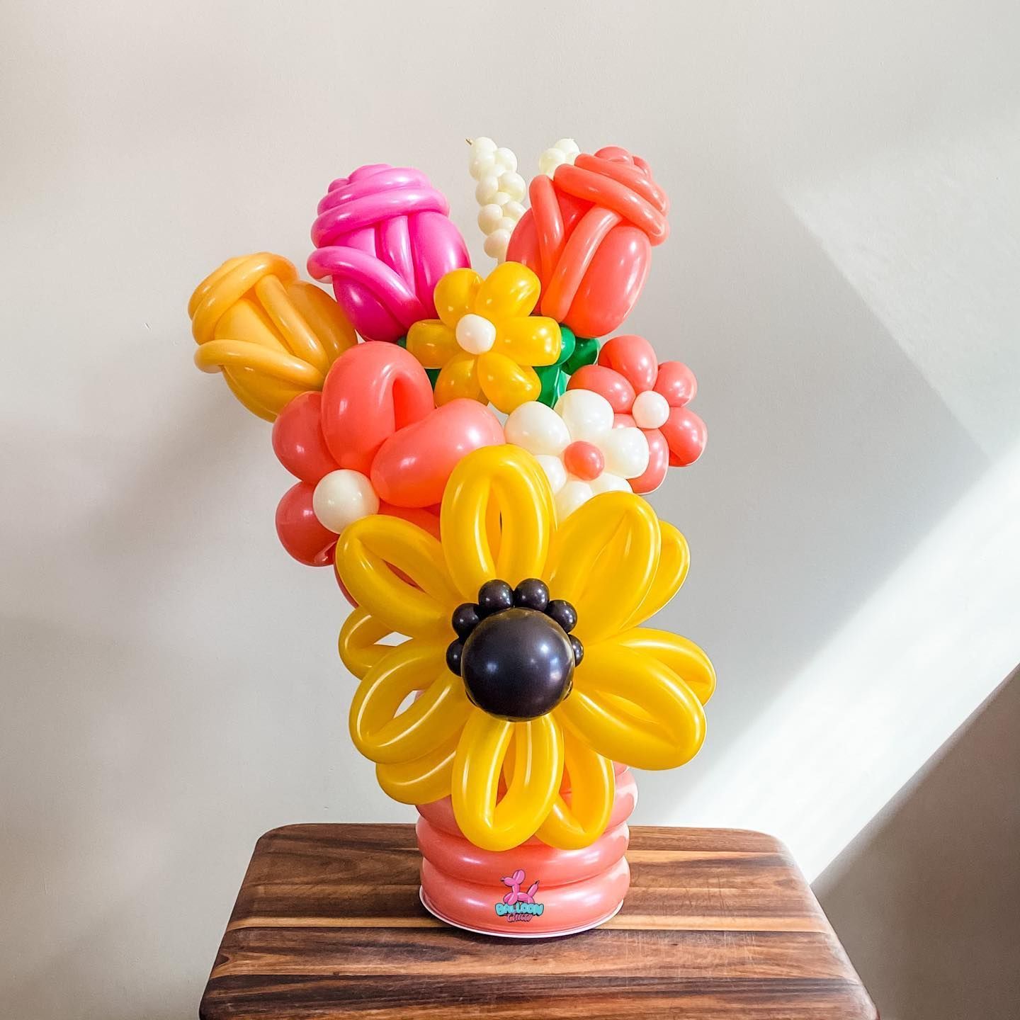 a vase filled with balloons shaped like flowers