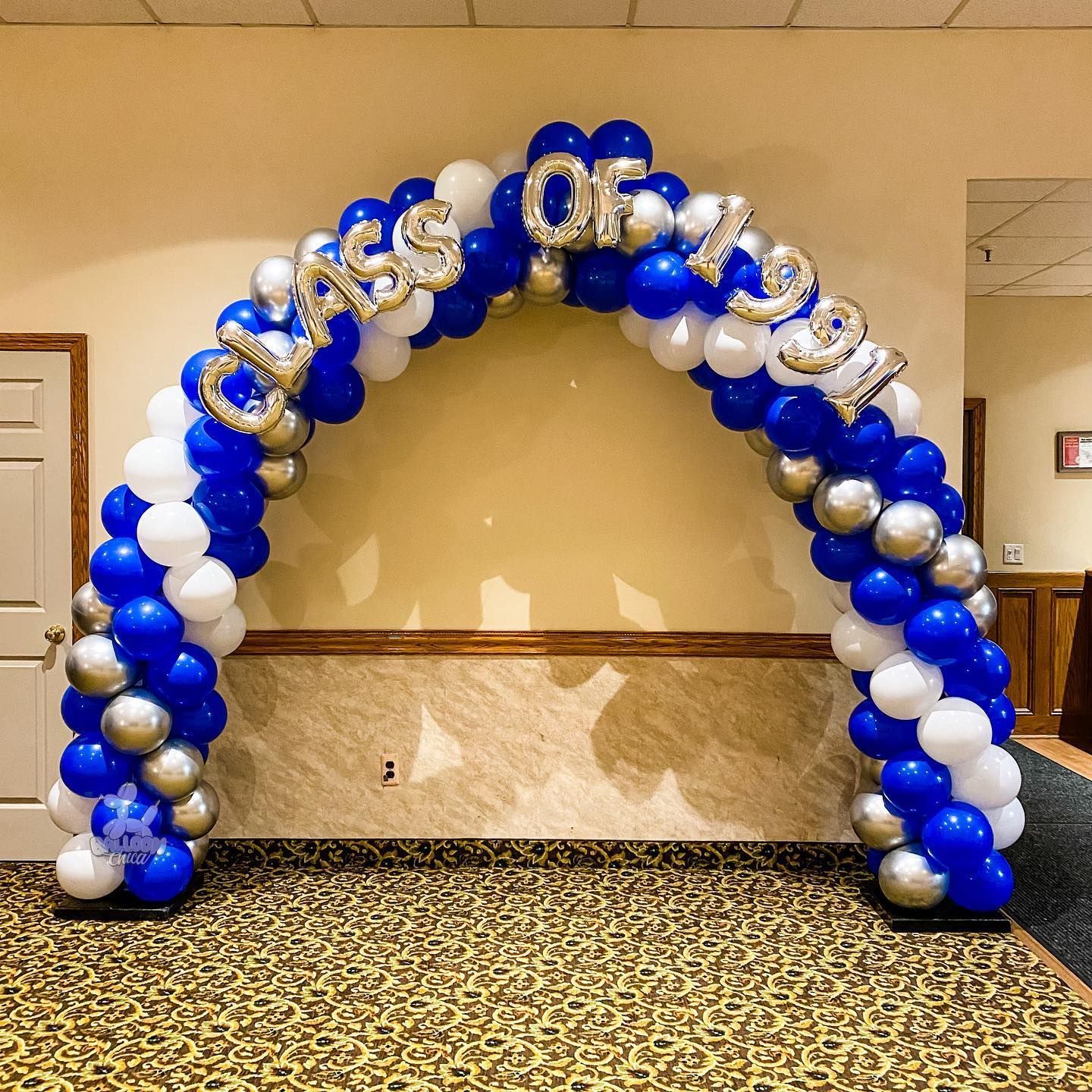 a blue and white balloon arch with the words class of 2021 on it