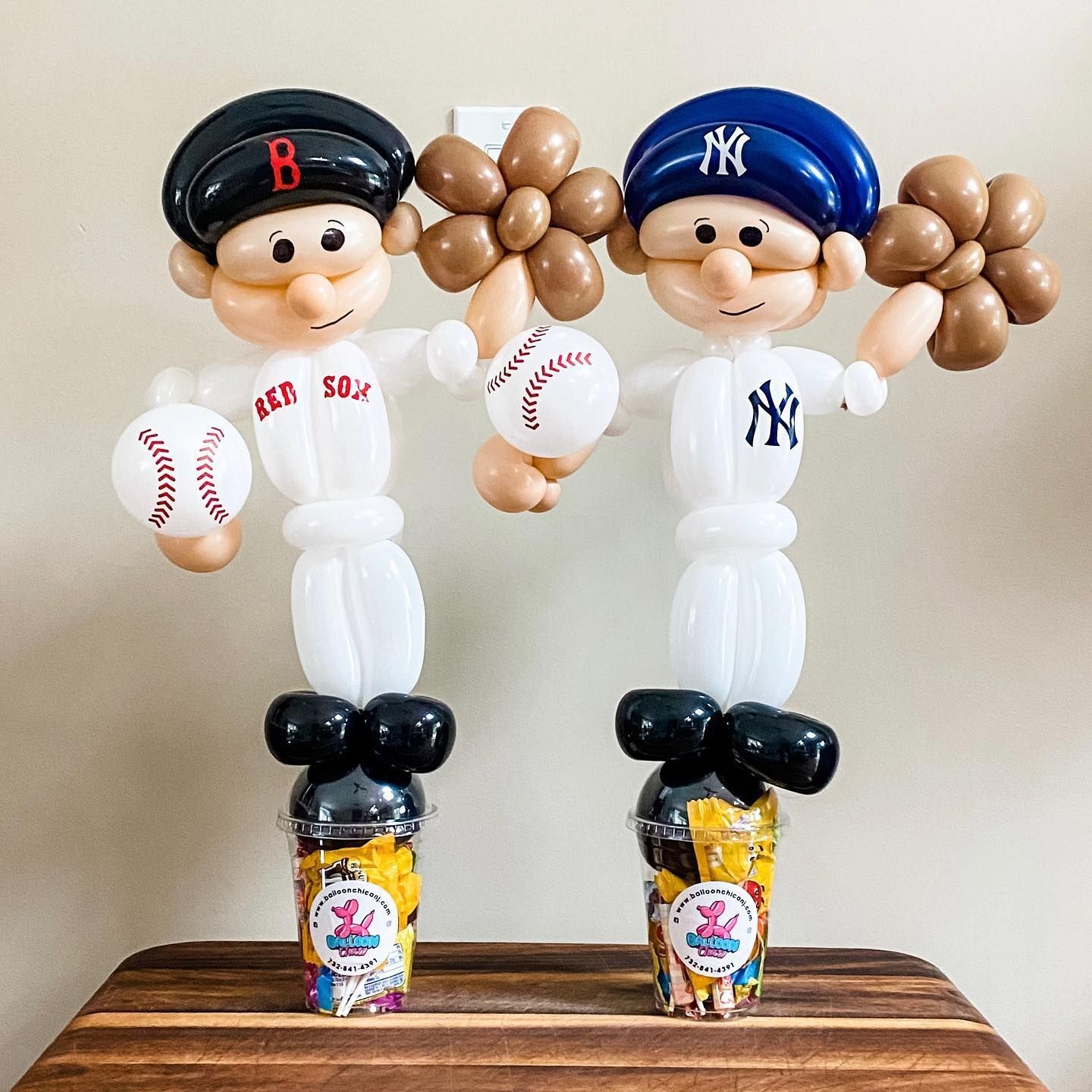 two baseball players made out of balloons are standing next to each other on a table