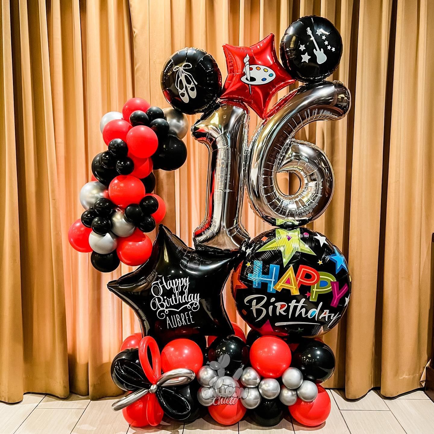 a bunch of balloons are sitting on the floor in front of a curtain