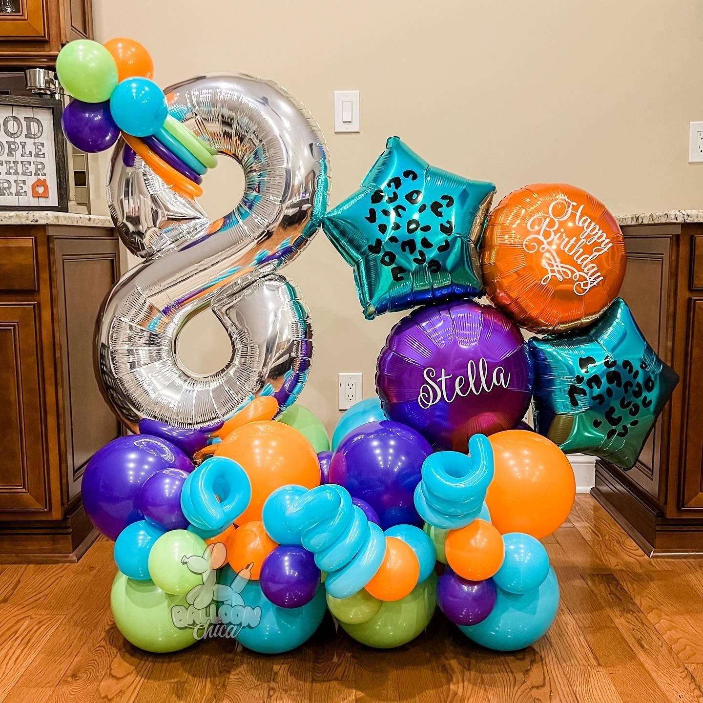 a bunch of balloons are sitting on a wooden floor in a room