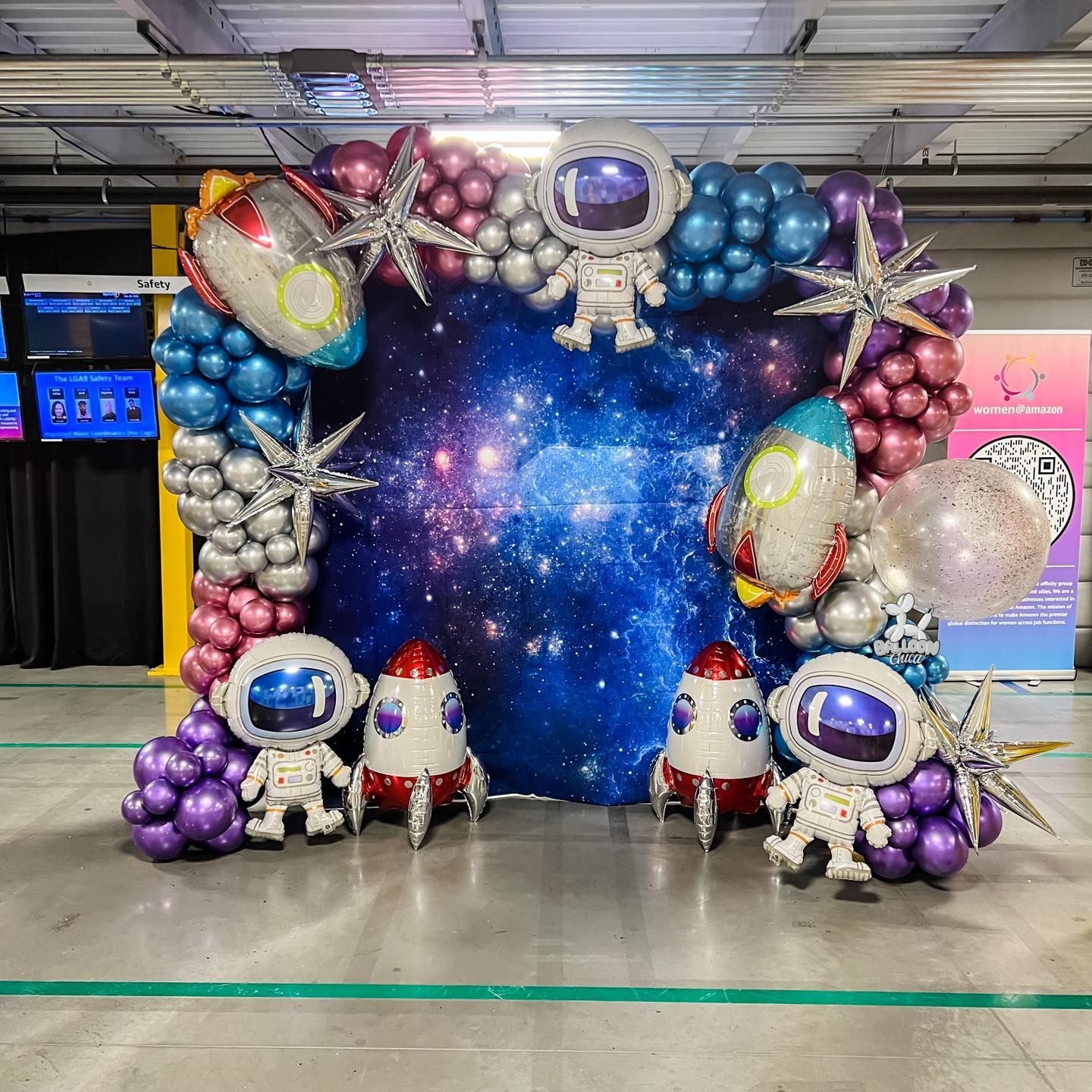 a bunch of balloons are sitting on the floor in front of a galaxy background