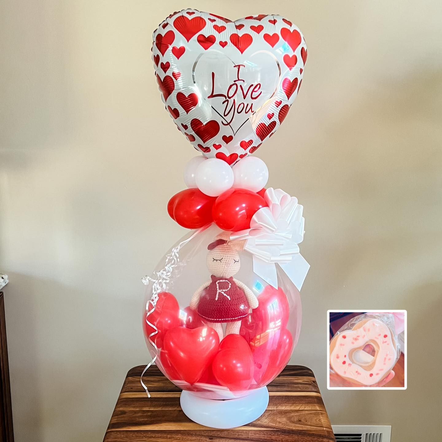 a stuffed animal is inside of a balloon with a heart shaped balloon .