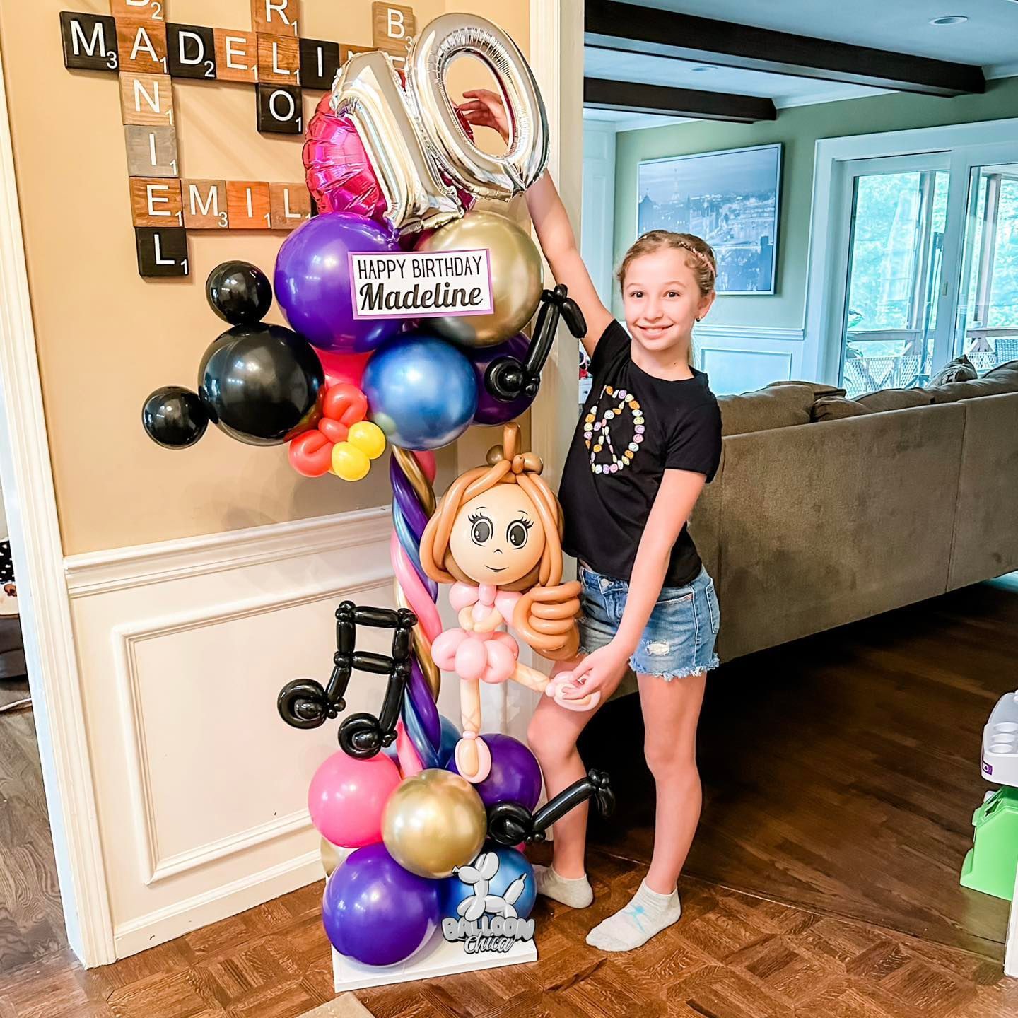 girl standing next to a balloon sculpture