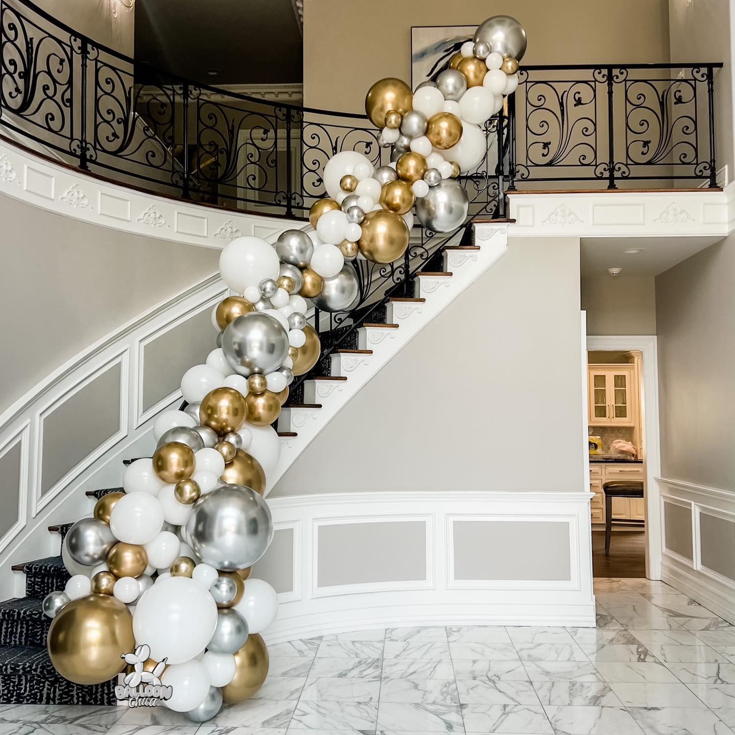 a staircase decorated with gold , silver and white balloons .