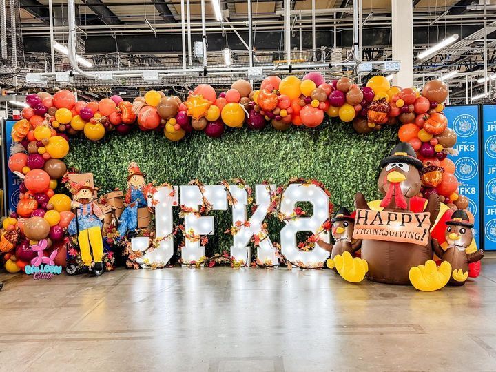 a group of people are standing in front of a sign that says happy thanksgiving
