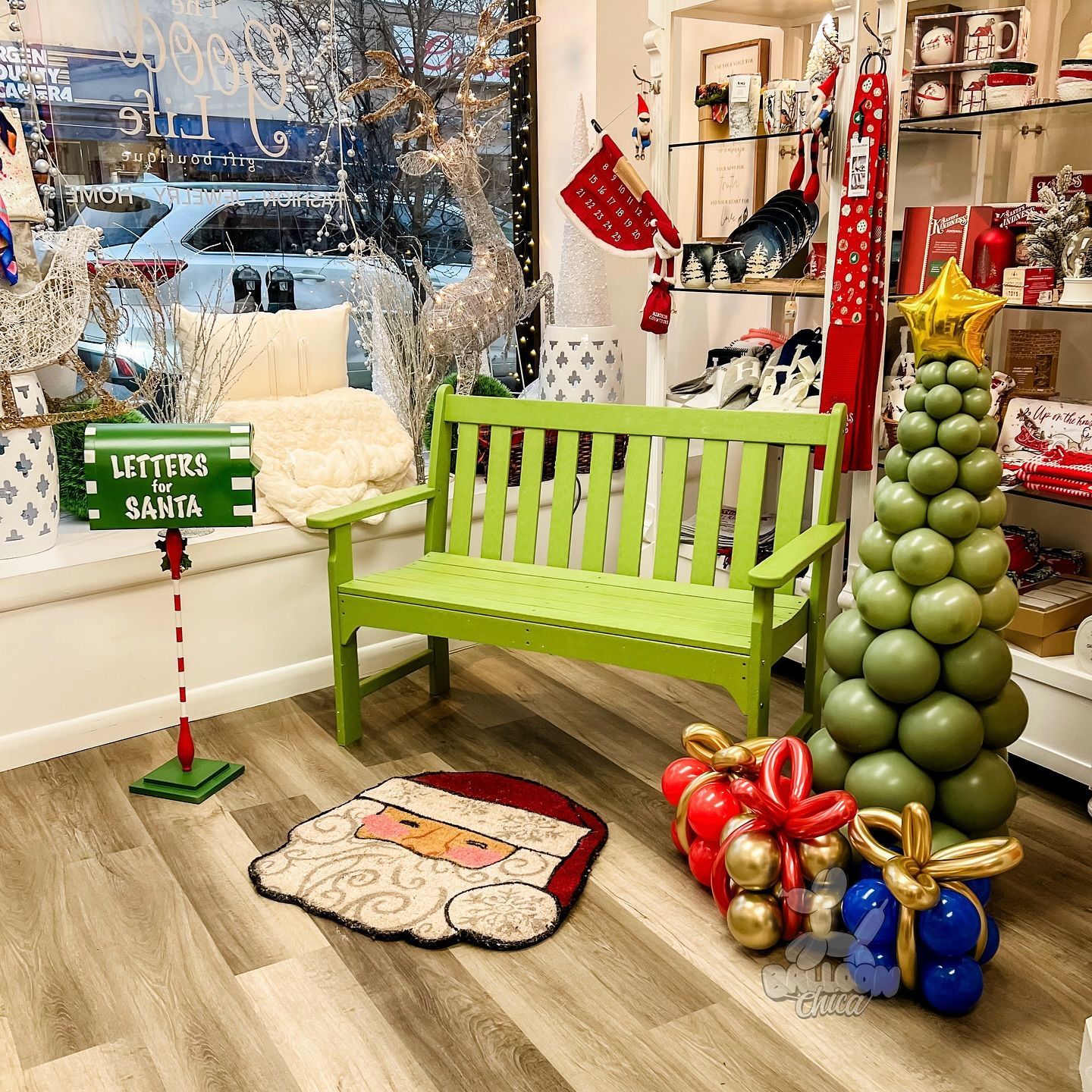 a green bench is sitting next to a christmas tree in a room decorated for christmas
