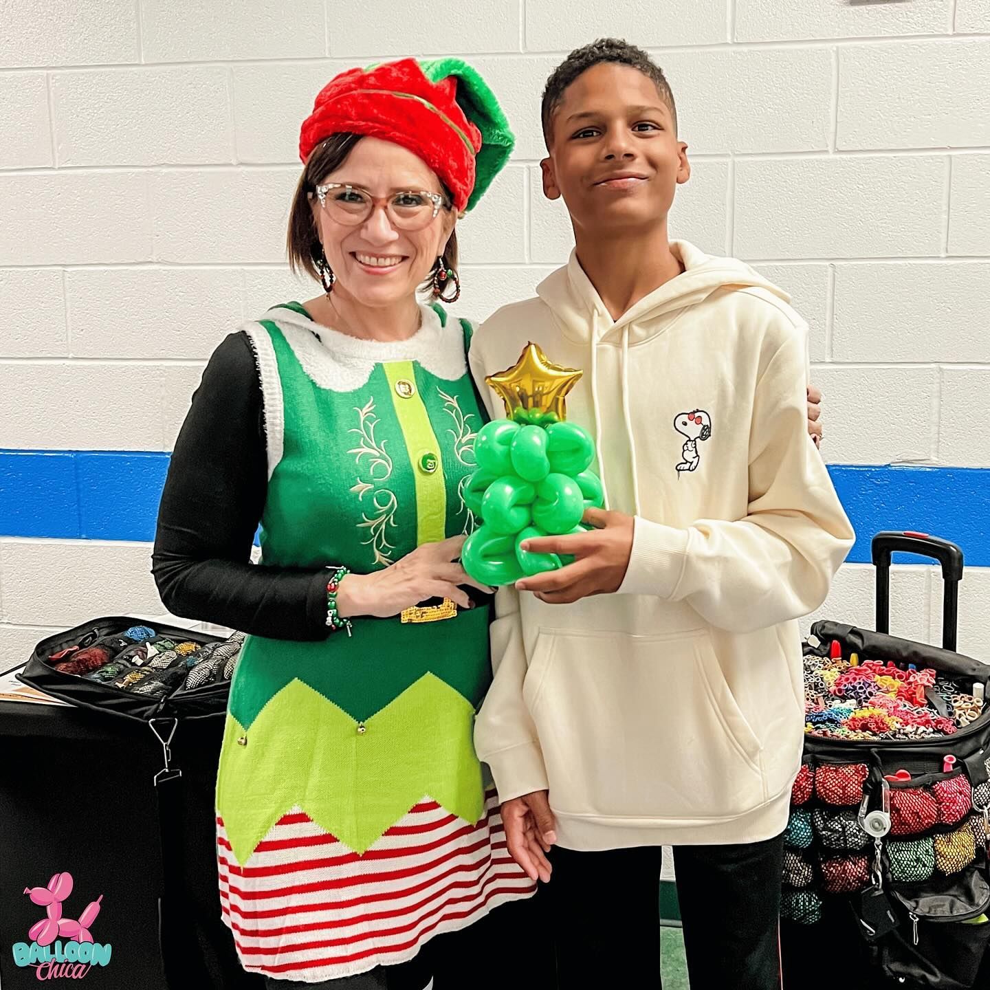 a woman dressed as an elf is standing next to a boy holding balloons