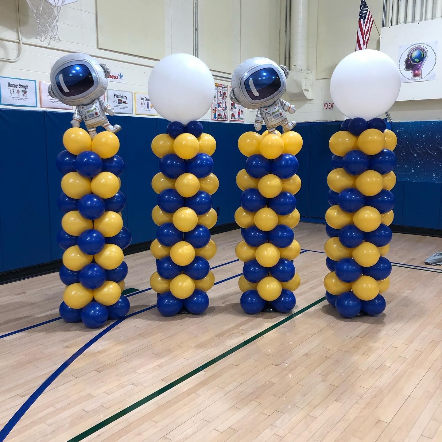 three columns of blue and yellow balloons with astronauts on them