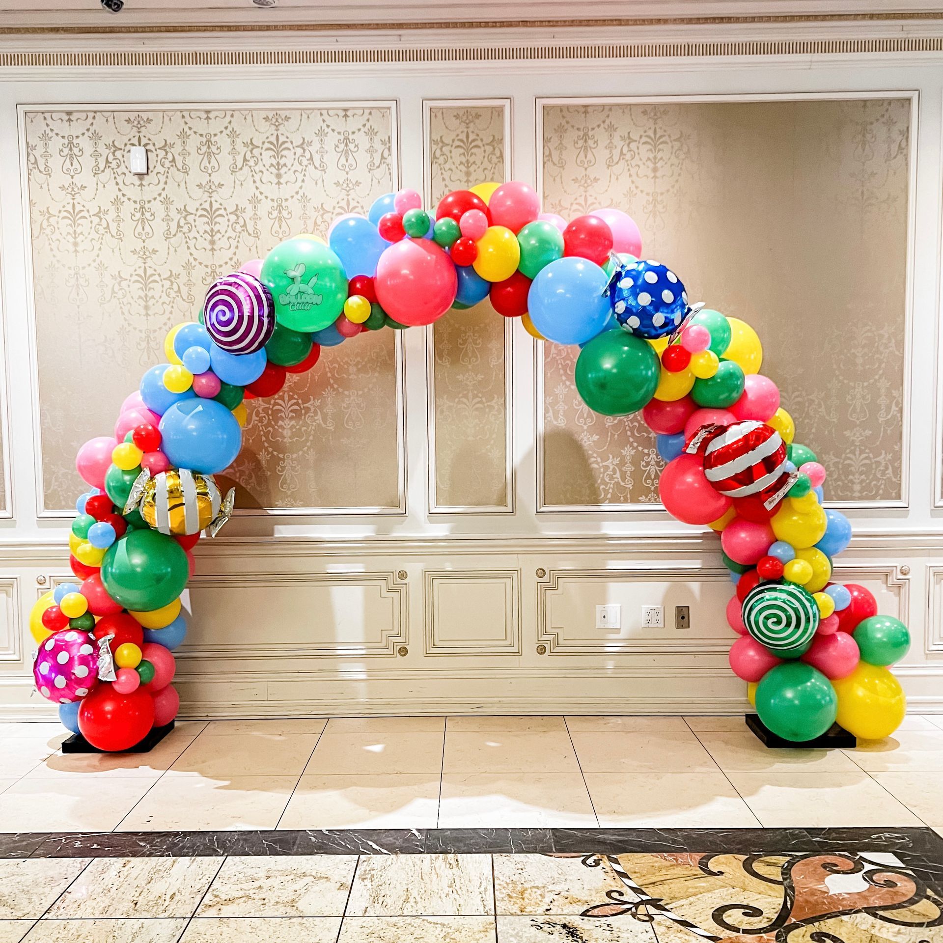 a room with a balloon arch that says will you marry me