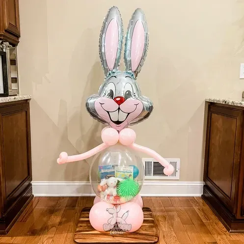 a large bunny balloon is sitting on top of a wooden table