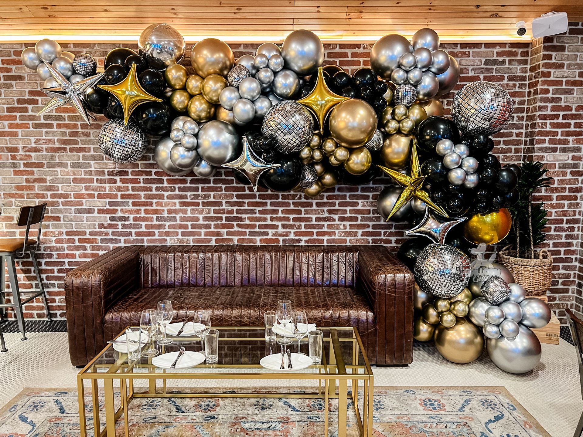 a living room with a couch , coffee table , and balloons on the wall .