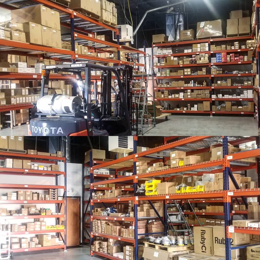 Forklift in a warehouse with shelves full of boxes.