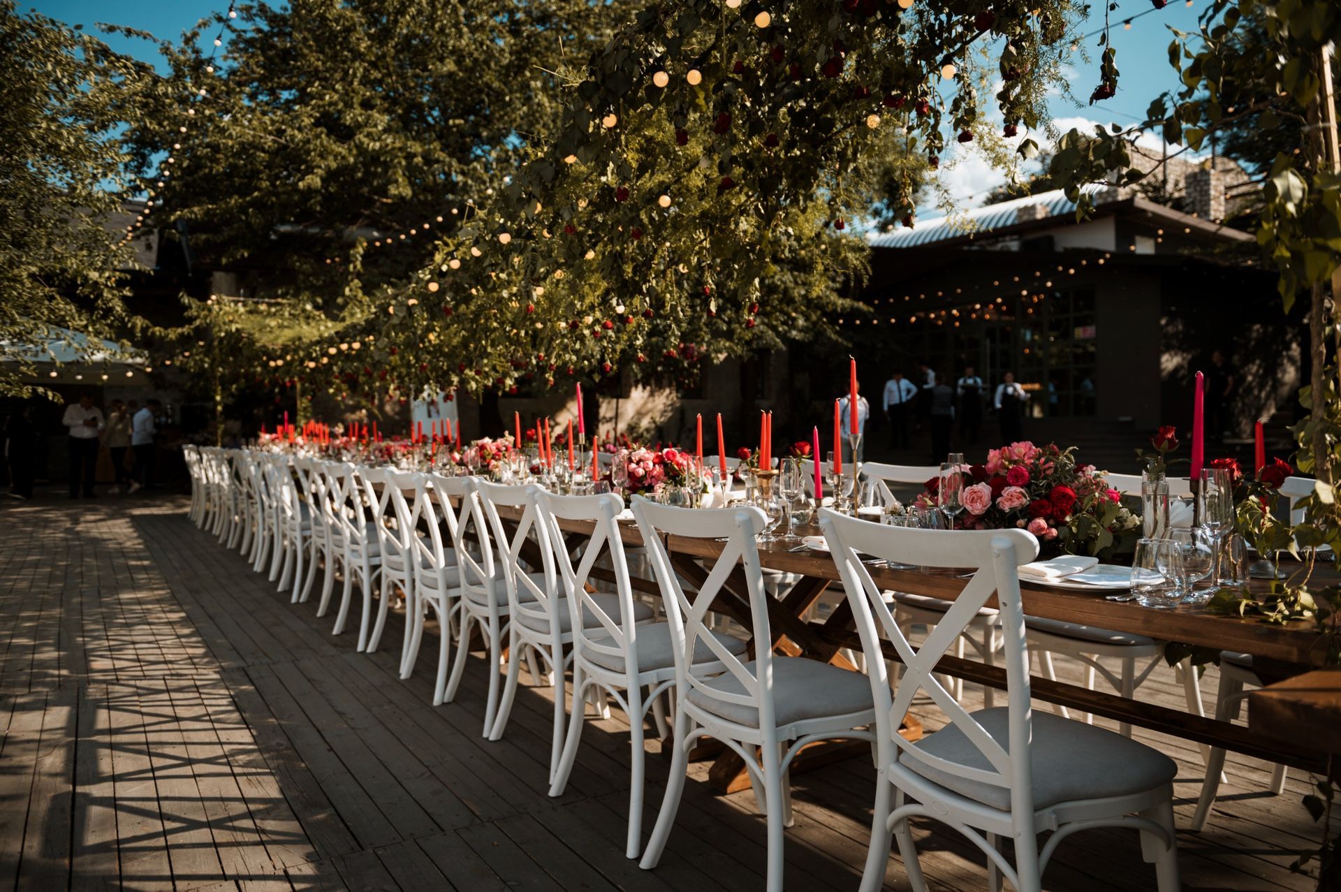 Una mesa larga con sillas blancas y velas preparadas para una recepción de boda. | Fonrecar. Organizadores de eventos