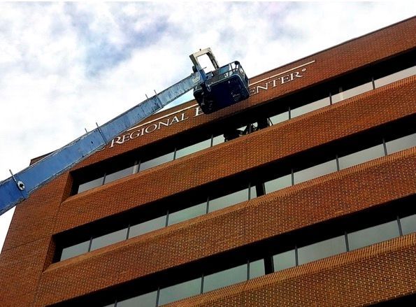 A large brick building with a crane on top of it.