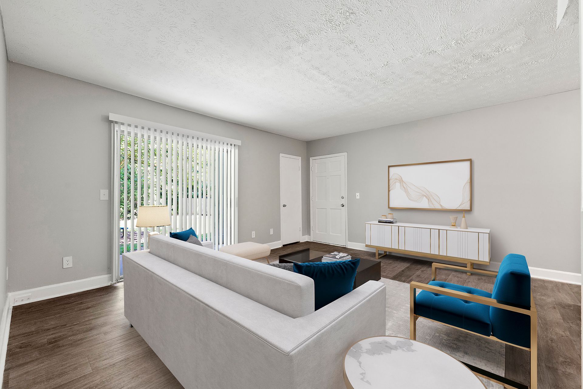 Bright living room with gray sectional sofa, blue chair, and white console table near a sliding glass door.