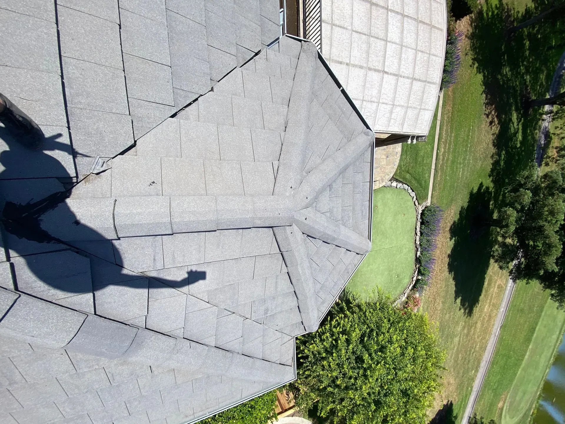 A shadow of a person is cast on the roof of a house