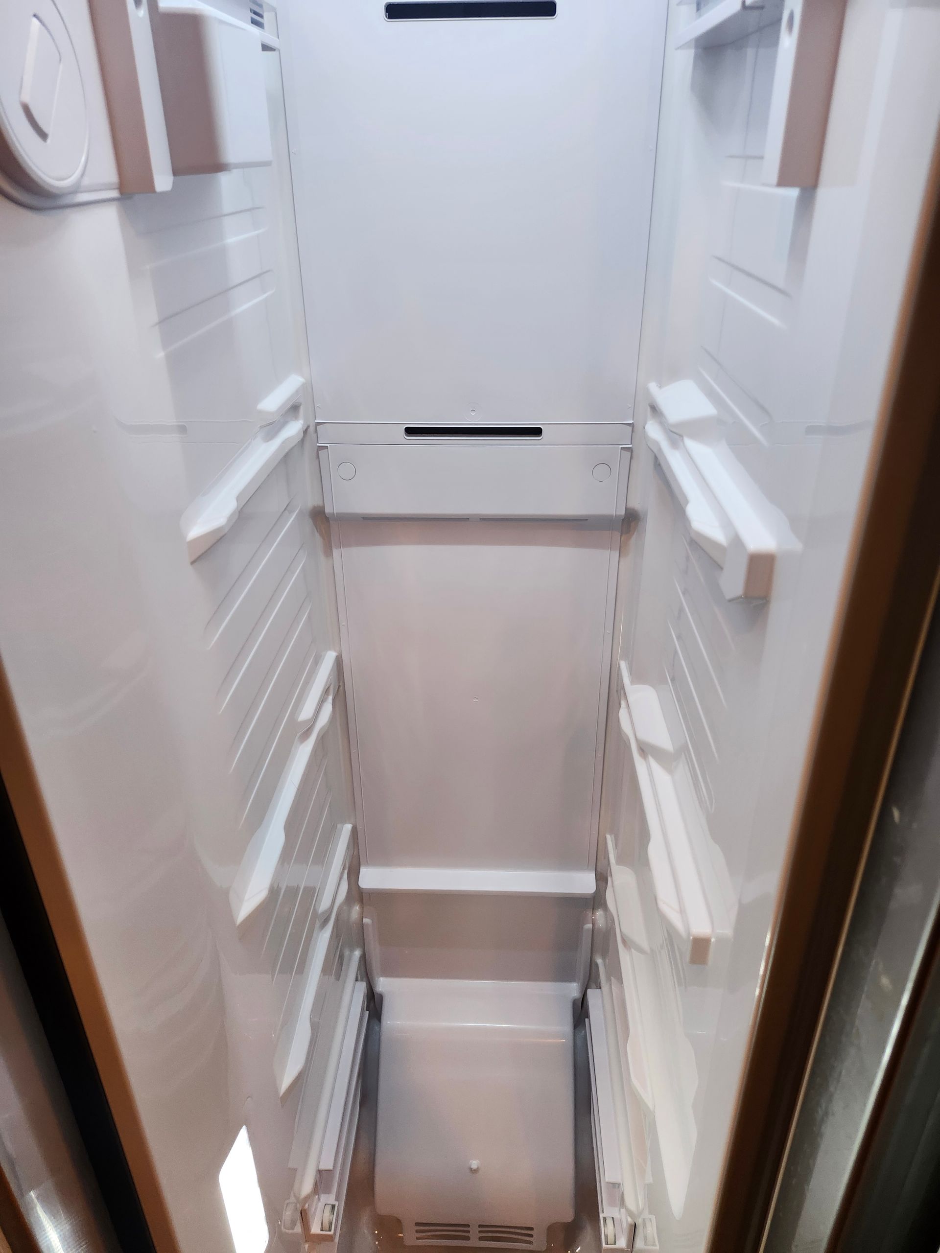 Narrow white stairwell or shaft with railings on both sides and a door at the top