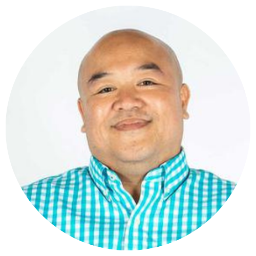 Smiling bald man in a turquoise checkered shirt against a white background